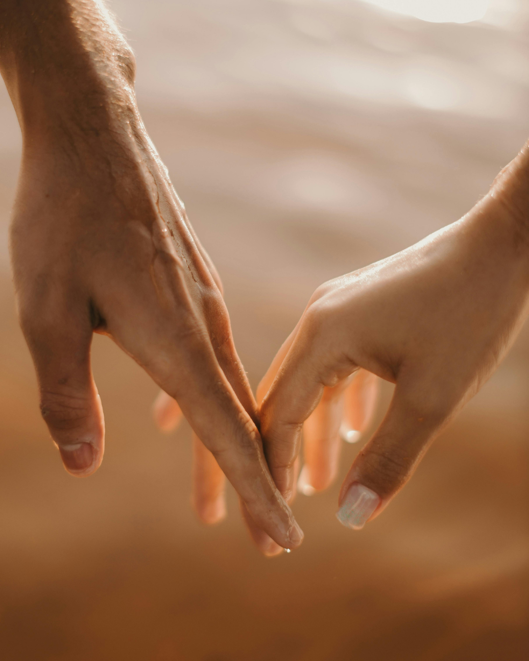 Intimate connection — hands touching in golden light